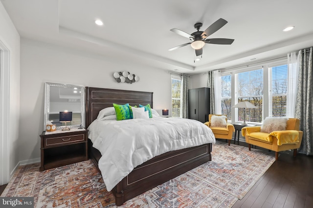 bedroom featuring ceiling fan, wood-type flooring, a tray ceiling, and recessed lighting