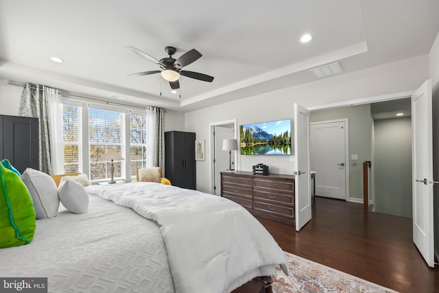 bedroom featuring recessed lighting, a ceiling fan, a raised ceiling, and dark wood-type flooring