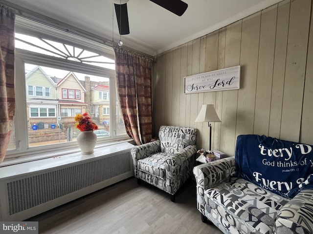 6207 Gardenia St, Philadelphia, PA 19144 - sitting room with wooden walls, ceiling fan, radiator, and wood finished floors
