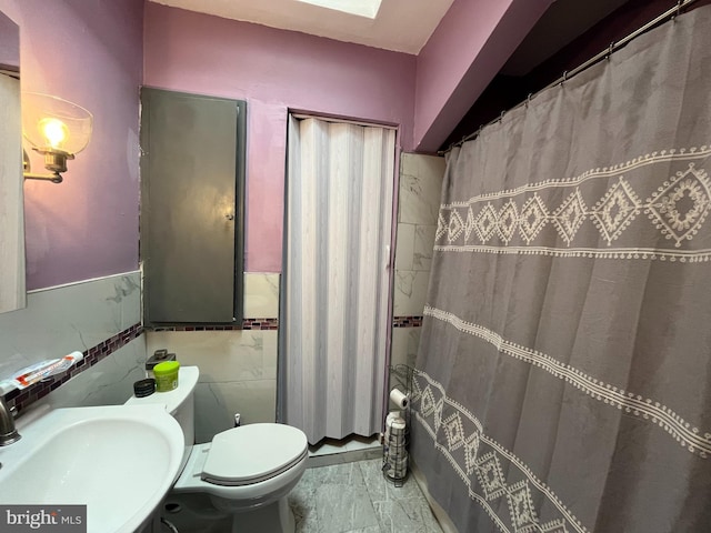 6207 Gardenia St, Philadelphia, PA 19144 - bathroom with a sink, tile walls, toilet, wainscoting, and marble finish floor