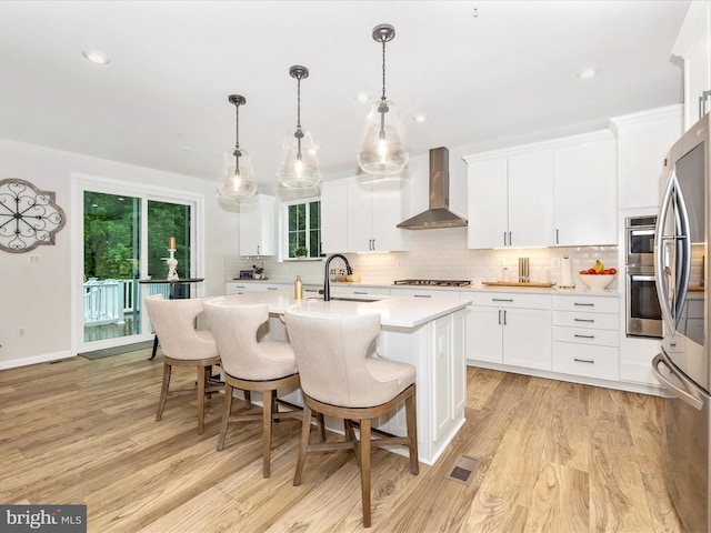 704 Kaplon Ct, Brunswick, MD 21716 - kitchen featuring wall chimney exhaust hood, light countertops, a sink, light wood-style flooring, and recessed lighting