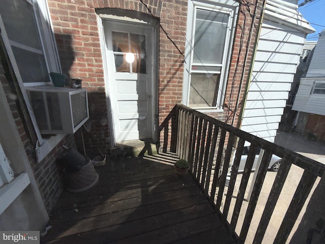 property entrance featuring brick siding and cooling unit