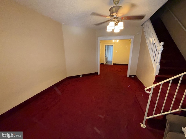 carpeted spare room featuring ceiling fan, stairway, and baseboards