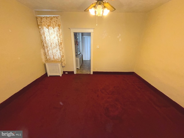 empty room with ceiling fan, carpet, and baseboards
