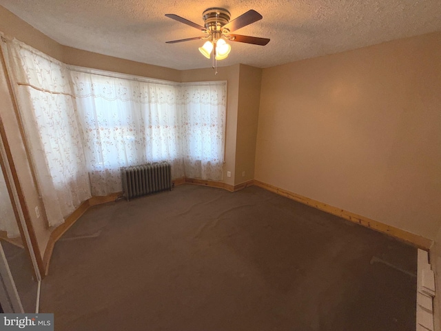 spare room featuring radiator heating unit, light carpet, baseboards, and a ceiling fan