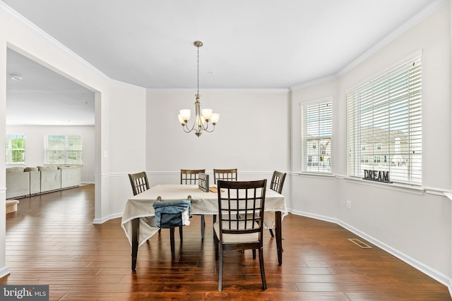 dining space featuring visible vents, dark wood-type flooring, crown molding, baseboards, and a chandelier