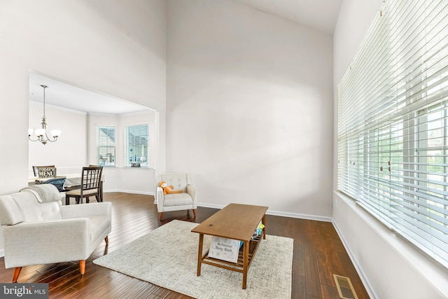 living room with a chandelier, baseboards, a high ceiling, dark wood-type flooring, and visible vents