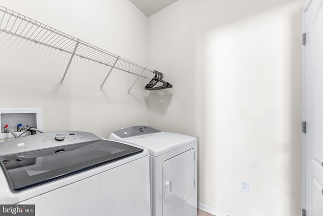 laundry room featuring separate washer and dryer and laundry area