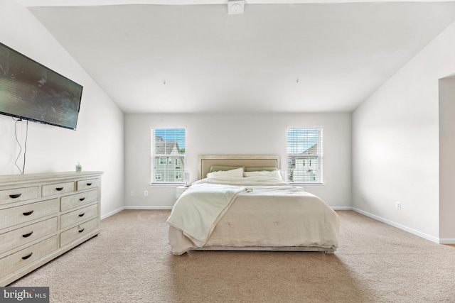 bedroom featuring baseboards, multiple windows, and light colored carpet