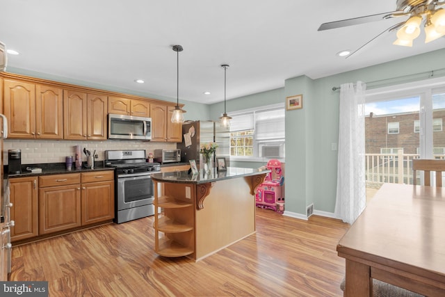 kitchen with open shelves, ceiling fan, stainless steel appliances, a kitchen island, and light wood-type flooring