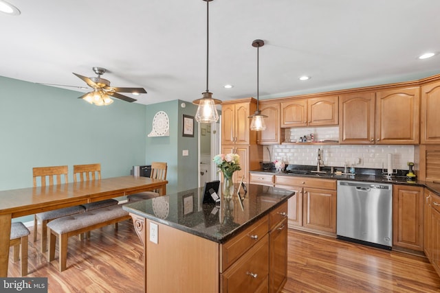kitchen featuring decorative backsplash, stainless steel dishwasher, light wood-style flooring, a sink, and recessed lighting