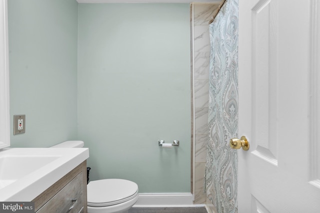 bathroom with vanity, toilet, a shower with shower curtain, and baseboards