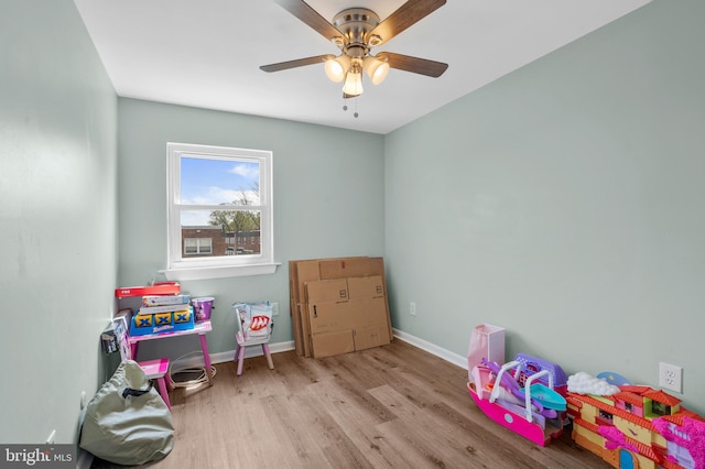 rec room featuring wood finished floors, ceiling fan, and baseboards