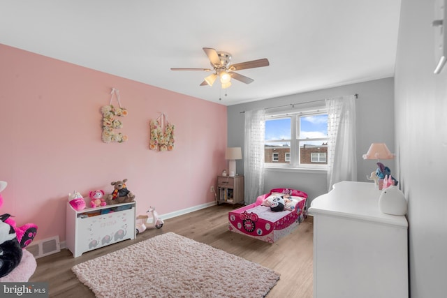 bedroom with baseboards, visible vents, a ceiling fan, and light wood-style floors