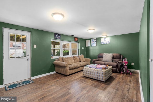 living room with baseboards, wood finished floors, and plenty of natural light