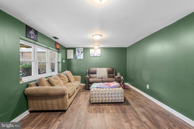 living room with visible vents, wood finished floors, and baseboards