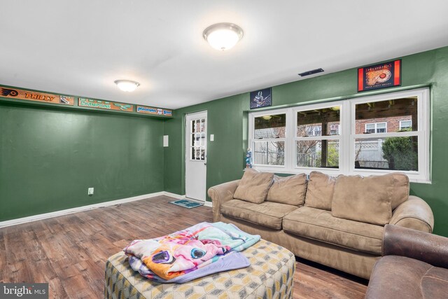 living room featuring wood finished floors, visible vents, and baseboards