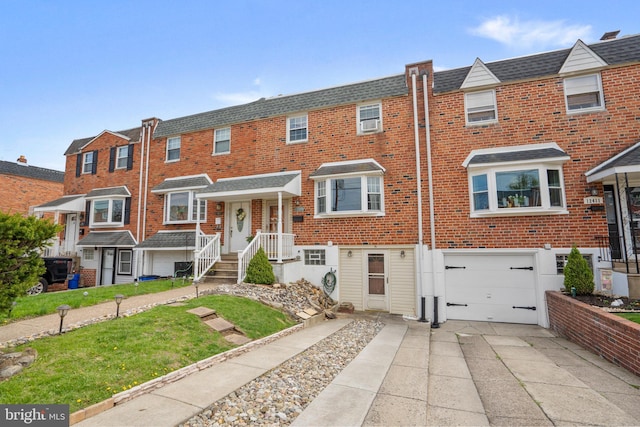 townhome / multi-family property with brick siding, roof with shingles, concrete driveway, and an attached garage