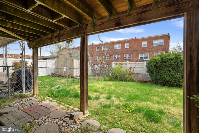 view of yard featuring an outdoor structure, a storage unit, and a fenced backyard