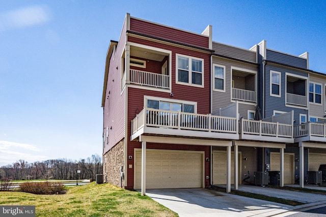 view of front of home featuring a garage, central air condition unit, driveway, and stone siding