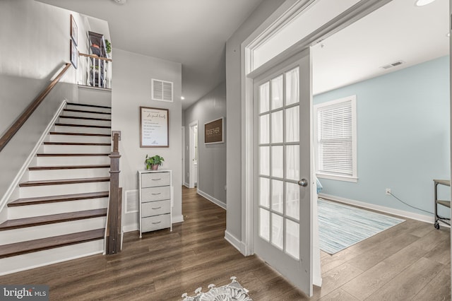 interior space with stairs, wood finished floors, visible vents, and baseboards