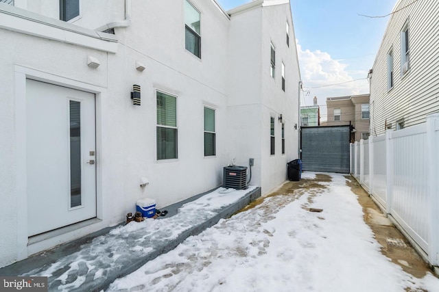 2625 Pratt St, Philadelphia, PA 19137 - view of snowy exterior with stucco siding, fence, and central AC