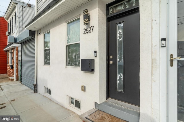 2625 Pratt St, Philadelphia, PA 19137 - doorway to property with stucco siding and visible vents