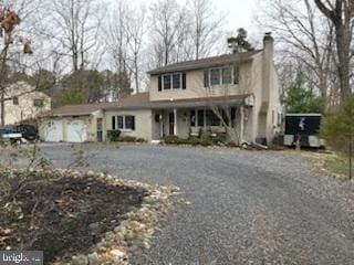 traditional-style house featuring an attached garage and driveway