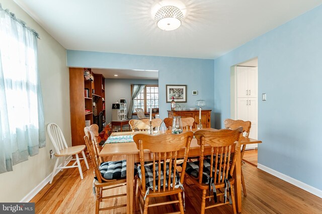 dining area with baseboards and light wood-style floors