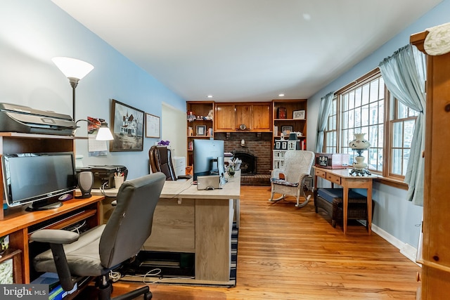 office area with recessed lighting, light wood-style floors, a brick fireplace, and baseboards