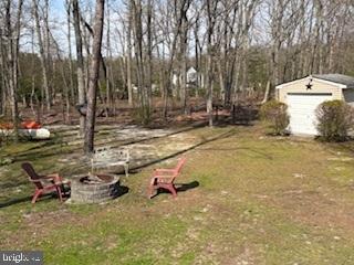 view of yard with a fire pit and an outdoor structure
