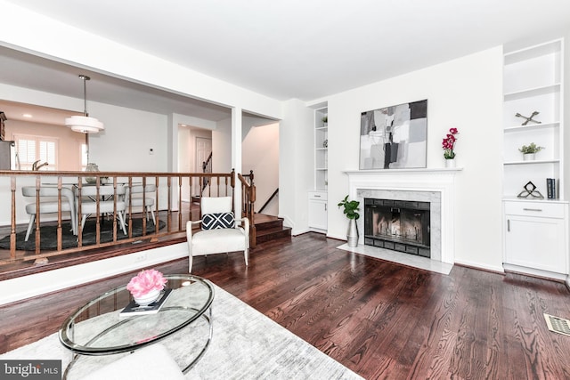 9644 Sutton Green Ct, Vienna, VA 22181 - living room featuring built in shelves, dark wood-style flooring, stairs, and a high end fireplace