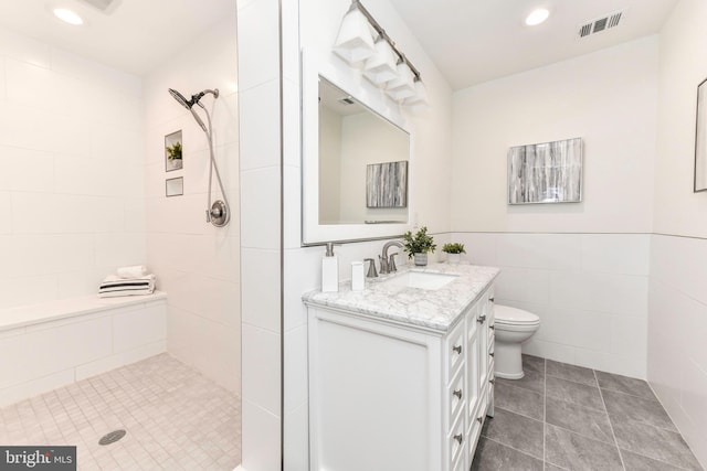 9644 Sutton Green Ct, Vienna, VA 22181 - bathroom featuring tiled shower, vanity, tile patterned flooring, tile walls, and toilet