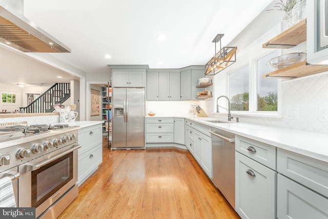 90 Indiantown Rd, Glenmoore, PA 19343 - kitchen with appliances with stainless steel finishes, a sink, open shelves, wall chimney range hood, and decorative backsplash