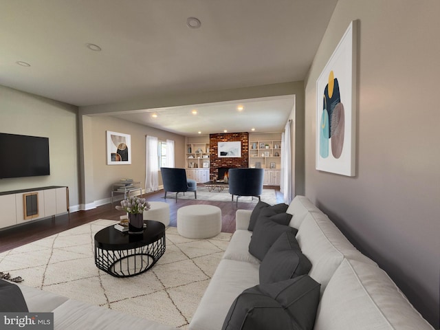 living room featuring recessed lighting, baseboards, wood finished floors, and a fireplace