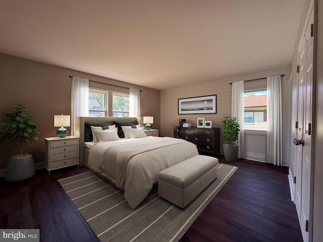 bedroom featuring dark wood-type flooring, baseboards, and multiple windows
