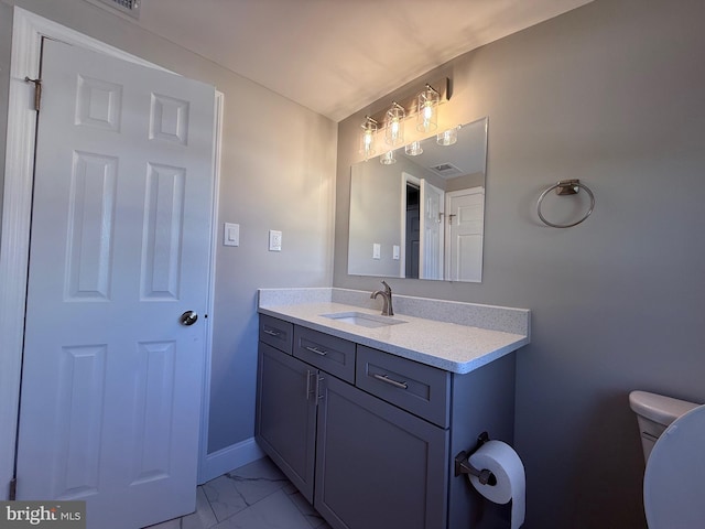bathroom with toilet, baseboards, marble finish floor, and vanity
