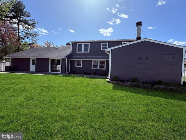 back of property featuring a lawn and an attached garage