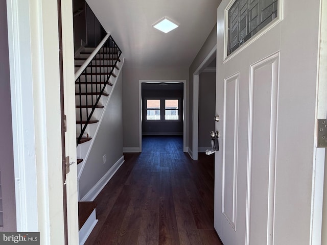 interior space with baseboards, dark wood-style floors, and stairway