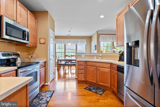 207 Secretariat Dr Unit M, Havre De Grace, MD 21078 - kitchen featuring appliances with stainless steel finishes, light wood-style flooring, light countertops, a sink, and a peninsula