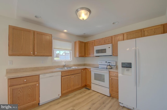 kitchen with recessed lighting, a sink, white appliances, light wood-style flooring, and light countertops