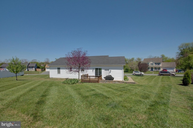 rear view of property featuring a deck and a lawn