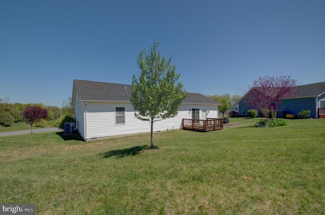 rear view of house with a wooden deck, roof with shingles, crawl space, a lawn, and central AC unit