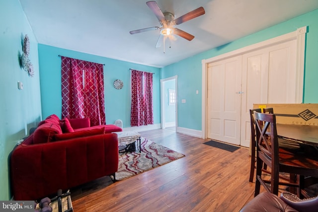 living room with wood finished floors, ceiling fan, and baseboards