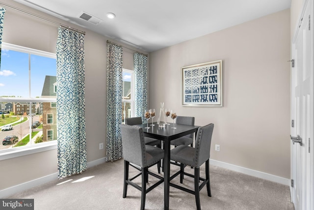 dining room featuring plenty of natural light, baseboards, visible vents, and carpet floors