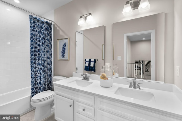 bathroom featuring toilet, shower / bath combo with shower curtain, a sink, and double vanity