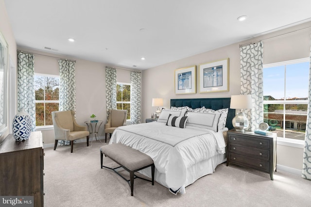 bedroom featuring recessed lighting, multiple windows, baseboards, and light carpet