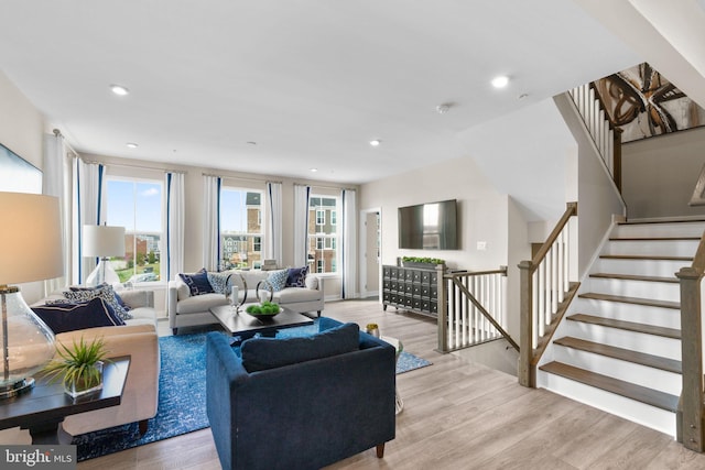 living room featuring stairs, light wood finished floors, and recessed lighting