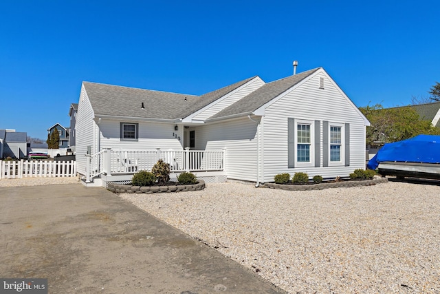 ranch-style house with a shingled roof and fence