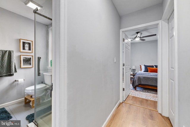 hall with baseboards and wood finished floors